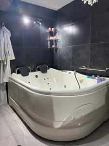 a white bath tub in a bathroom with a tiled wall at Residencia en Apodaca Nuevo León in Monterrey