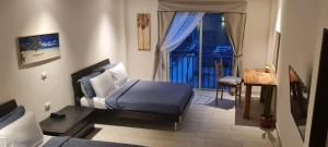a small bedroom with a bed and a balcony at LOP Inn San Jose Aeropuerto - Costa Rica in Ciudad Cariari