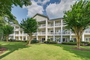 an exterior view of a large white building with trees at Serene Myrtle Beach Condo with Community Pool! in Myrtle Beach