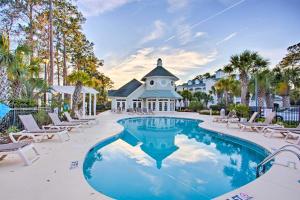 una piscina en un complejo con sillas y un edificio en Serene Myrtle Beach Condo with Community Pool! en Myrtle Beach