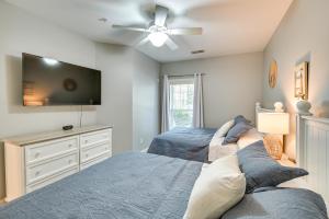 a bedroom with two beds and a flat screen tv at Serene Myrtle Beach Condo with Community Pool! in Myrtle Beach
