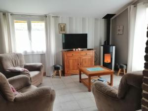 ein Wohnzimmer mit 2 Stühlen und einem Flachbild-TV in der Unterkunft Cottage, Les Grandes Ventes in Les Grandes-Ventes