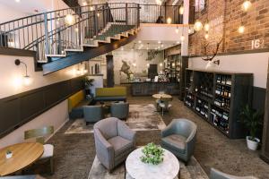 a lobby with chairs and tables and a staircase at Hotel Windrow Downtown Ellensburg in Ellensburg
