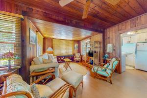 a living room with wooden walls and a kitchen at The Wee Cottage in Anna Maria