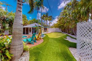 un patio con una pista de tenis y una casa en The Wee Cottage en Anna Maria