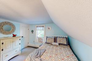 a bedroom with a bed and a mirror on the wall at Come About Cottage in Wareham