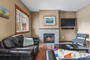 Una sala de estar con un sofá y una chimenea. en King Bed - Top Floor Grizzly, en Canmore