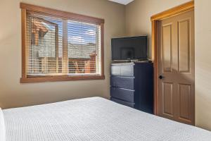 Un dormitorio con una cama y un televisor y una ventana. en King Bed - Top Floor Grizzly, en Canmore 20 fotos más