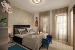 a bedroom with a bed and a blue chair at Family friendly house with a swimming pool Maslenica, Novigrad - 20492 in Maslenica +21 photos
