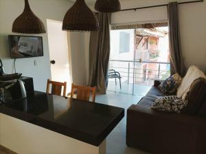 een woonkamer met een zwarte tafel en een bank bij Porto Ville Home - AP 2 quartos in Porto Seguro