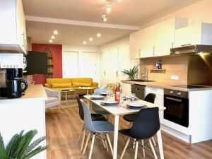 a kitchen with a table and chairs in a room at La Vila Joiosa in Saint-Herblain