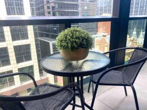 een glazen tafel met een potplant op een balkon bij So Unique! Collins Street Vibe 2B2B in Melbourne