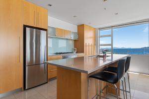 uma cozinha com um frigorífico de aço inoxidável e um balcão em Waimahana Apartment 8 em Taupo