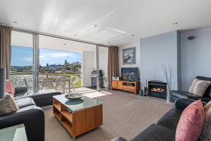 a living room with couches and a fireplace at Waimahana Apartment 8 in Taupo
