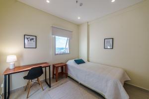 Schlafzimmer mit einem Bett, einem Schreibtisch und einem Fenster in der Unterkunft Villa morra, a pasos de los shoppings! in Asunción
