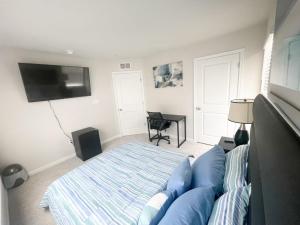 a bedroom with a blue bed and a flat screen tv at Ruby Home in Bowie