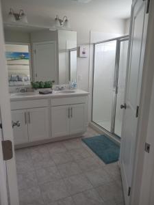 a white bathroom with two sinks and a shower at Ruby Home in Bowie