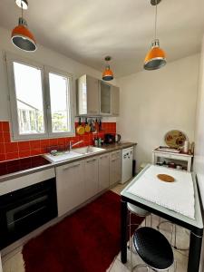 eine Küche mit weißen Schränken und roten Fliesen in der Unterkunft Appartement SAINTE ELISABETH - République in Paris