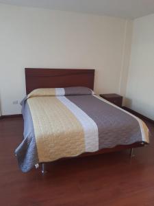 Bett in einem Schlafzimmer mit Holzboden in der Unterkunft Andaluz Townhouse for Rent in Loja