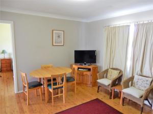 a living room with a table and chairs and a television at Donlan's Delight in Mollymook