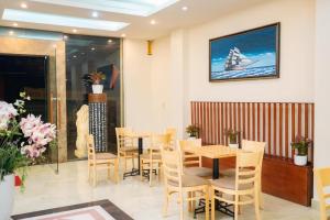 ein Restaurant mit Tischen und Stühlen und ein Boot an der Wand in der Unterkunft Hoang Yen Hotel - Gần đại học Sư Phạm TN in Thái Nguyên