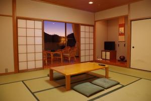 a living room with a table and a dining room at 有馬 瑞宝園 in Kobe