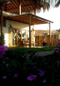 a house with a hammock in front of it at Panorama garden inn in Máncora