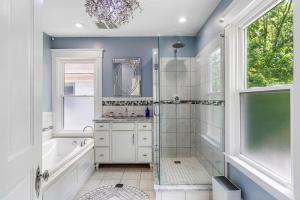 a bathroom with a shower and a sink and a mirror at Modern Oakley Retreat - King Bed - Free Parking - Centrally Located in Cincinnati +42 photos