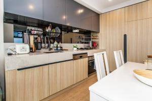a kitchen with wooden cabinets and a counter top at 2 Bed Apt with CAR Parking in SouthYarra（TF150221） in Melbourne