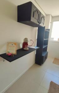 - une cuisine avec une étagère et une théière dans l'établissement Apto em Santo Ângelo, à Santo Ângelo
