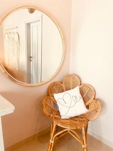 a mirror over a rattan chair with a pillow on it at Follow Your Dreams Gili Air in Gili Islands