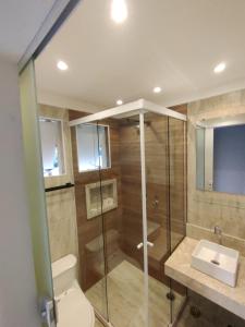 ein Bad mit einer Dusche, einem WC und einem Waschbecken in der Unterkunft Paúba Beach Hotel in Pauba
