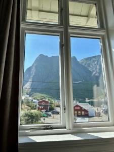 uma janela com vista para uma montanha em Det Gamle Hotellet Guesthouse em Reine