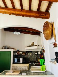 a kitchen with a stove and a green door at Cortile Padre Vincenzo in Erice