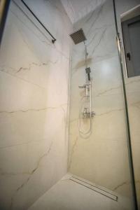 a bathroom with a shower with a marble wall at Etheras Luxury apartment in Loutraki