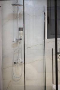 a shower with a glass door in a bathroom at Etheras Luxury apartment in Loutraki