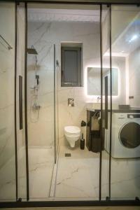 ein Bad mit einer Dusche, einem WC und einem Waschbecken in der Unterkunft Etheras Luxury apartment in Loutraki