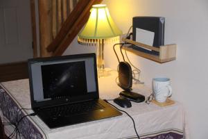 un ordenador portátil sobre una cama con lámpara en Tunk Valley Ranch House, en Riverside