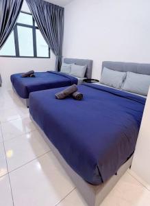 twee bedden in een kamer met blauwe lakens bij TheSun #3BR #PISA #FTZ #FamilyStay #USM in Bayan Lepas