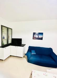 un soggiorno con divano blu e specchio di Civico 71 a Casa Santa