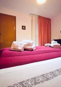 un letto con lenzuola rosa e cuscini bianchi di Civico 71 a Casa Santa