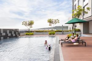 un grupo de personas en una piscina en un hotel en Holiday Inn Sepang - Airport, en Sepang