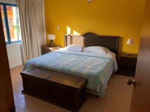 1 dormitorio con cama y pared amarilla en Casa en Caribbean con Wifi, en Tucacas
