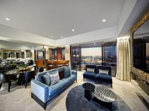 a living room with a blue couch and a table at Emporium Hotel South Bank in Brisbane