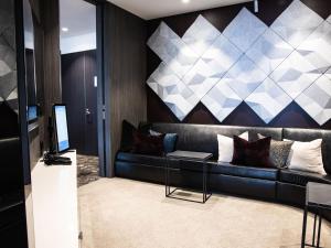 a living room with a black couch with pillows at Emporium Hotel South Bank in Brisbane