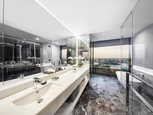 a bathroom with two sinks and a large mirror at Emporium Hotel South Bank in Brisbane
