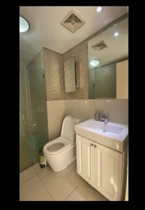y baño con aseo, lavabo y ducha. en Calyx Residences, 18H, en Cebú