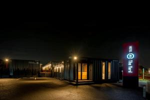 a sign in front of a building at night at HOTEL R9 The Yard Kanumanishimoro in Kanuma