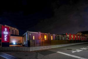 a row of buildings on a street at night at HOTEL R9 The Yard Kanumanishimoro in Kanuma