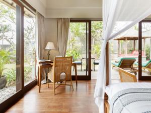 1 dormitorio con 1 cama, mesa y sillas en The Shanti Residence by Elite Havens, en Nusa Dua